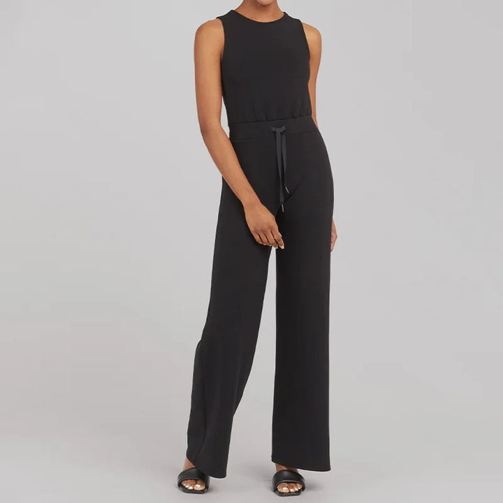 Grå elegant långärmad jumpsuit med justerbart midjebälte som framhäver en smickrande silhuett.