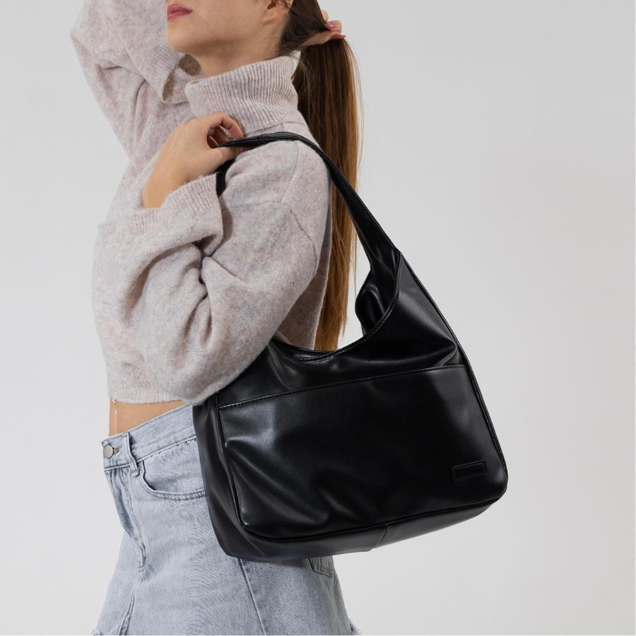 Kvinna bär elegant brun axelväska, perfekt som praktisk vardagsaccessoar med smart design.