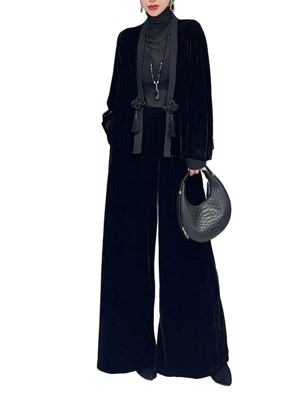 Elegant svart kvinnors V-ringad kappa och vida byxor set i silkesvelour. Perfekt för höstmode.