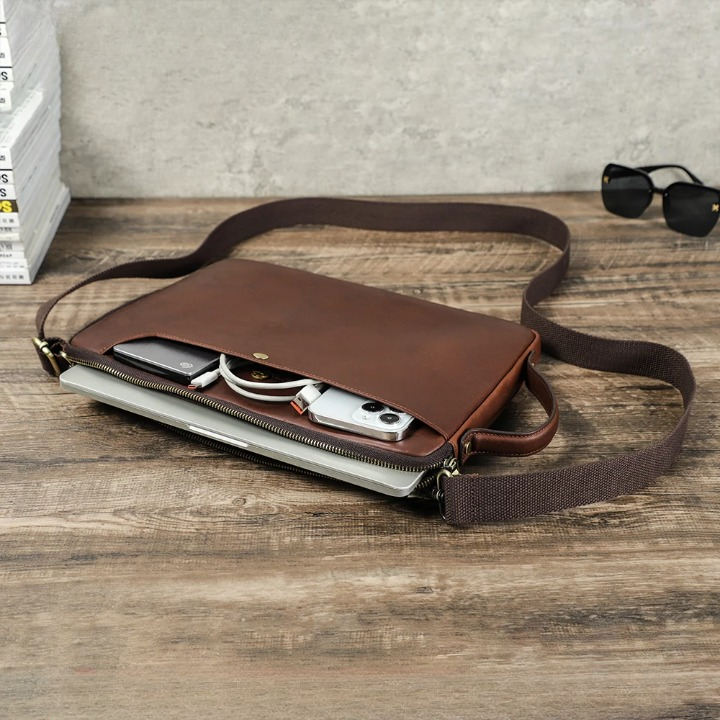 Öppen elegant laptopväska med organiserade fack för bärbar dator, dokument och tillbehör. Perfekt för kontoret.