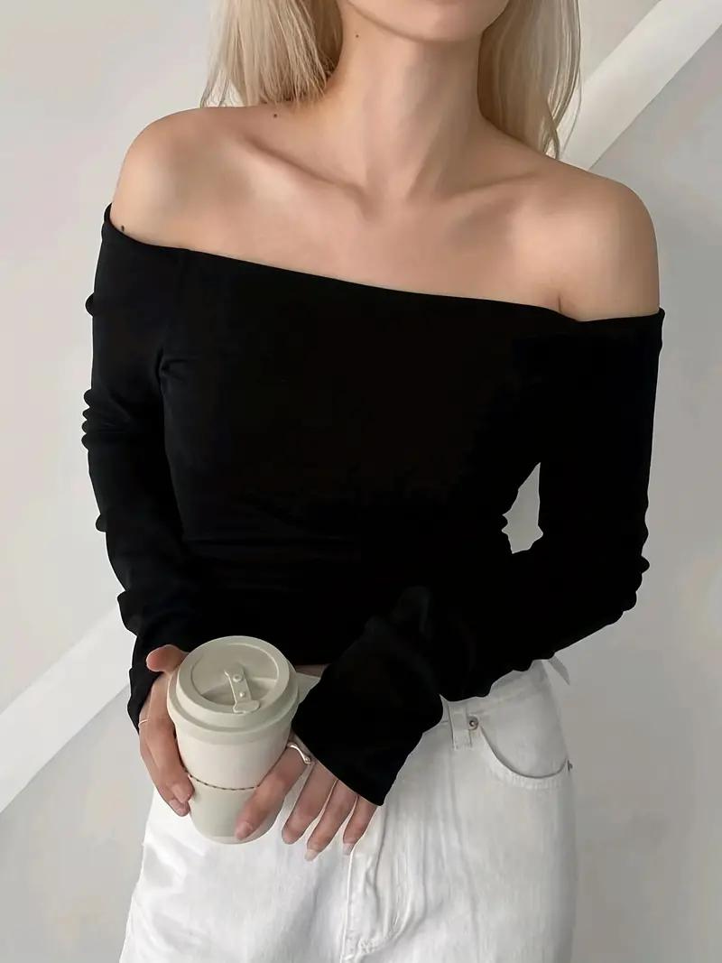 Modern axelbar långärmad damtopp med offshoulder design. En trendig modetröja i klassiska färger.