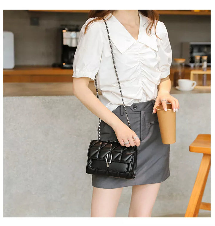 Svart lyxig damhandväska med kedjerem. Perfekt som axelväska eller crossbody för en elegant look.