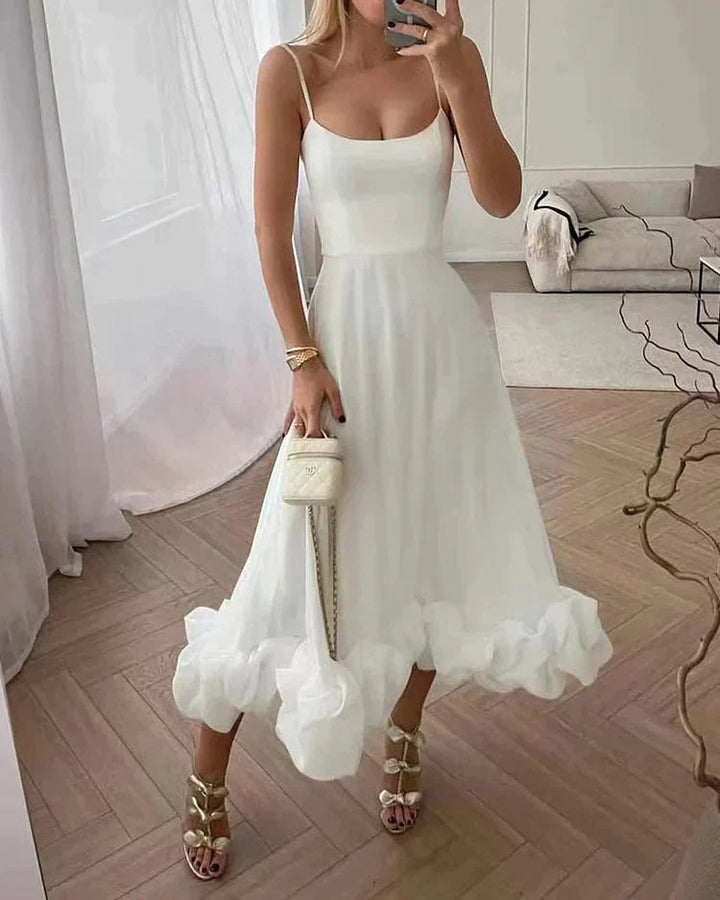 Detaljbild av elegant midi festklänning med vackert fall. Lyxigt tyg för festmode och sommarkvällar.