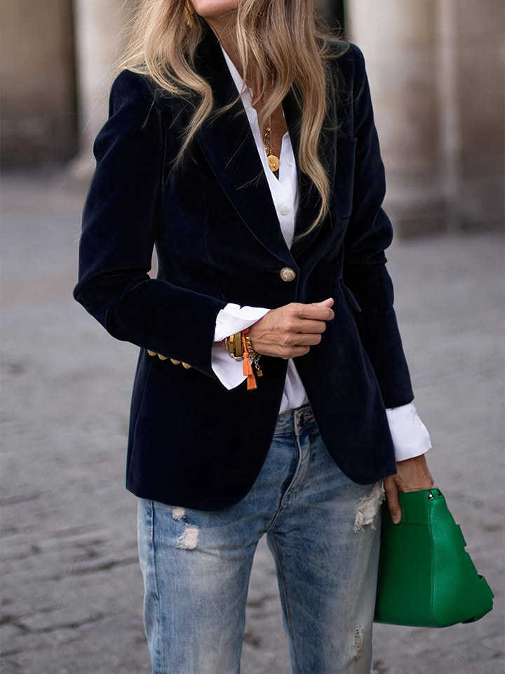 Kvinna bär en stilren svart sammetsblazer med guldknappar, elegant höstmode
