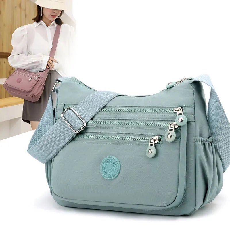Elegant svart vattentät dam messenger väska. Perfekt som crossbodyväska för vardag och resor.