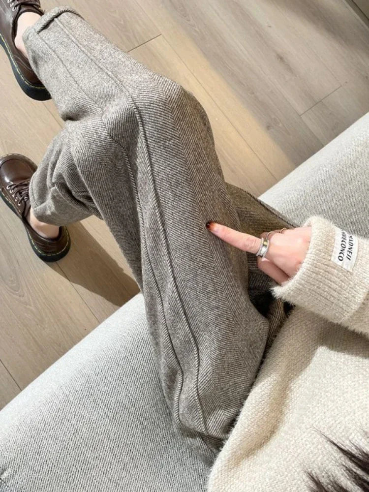 Helsotsbild av dam i eleganta svarta vida byxor i polyester, från sidan.