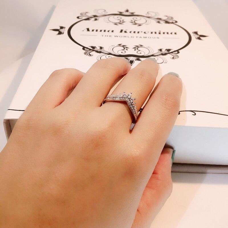 Närbild på elegant V-ring i silverstil med detaljerade kristaller. En modern och chic damring.