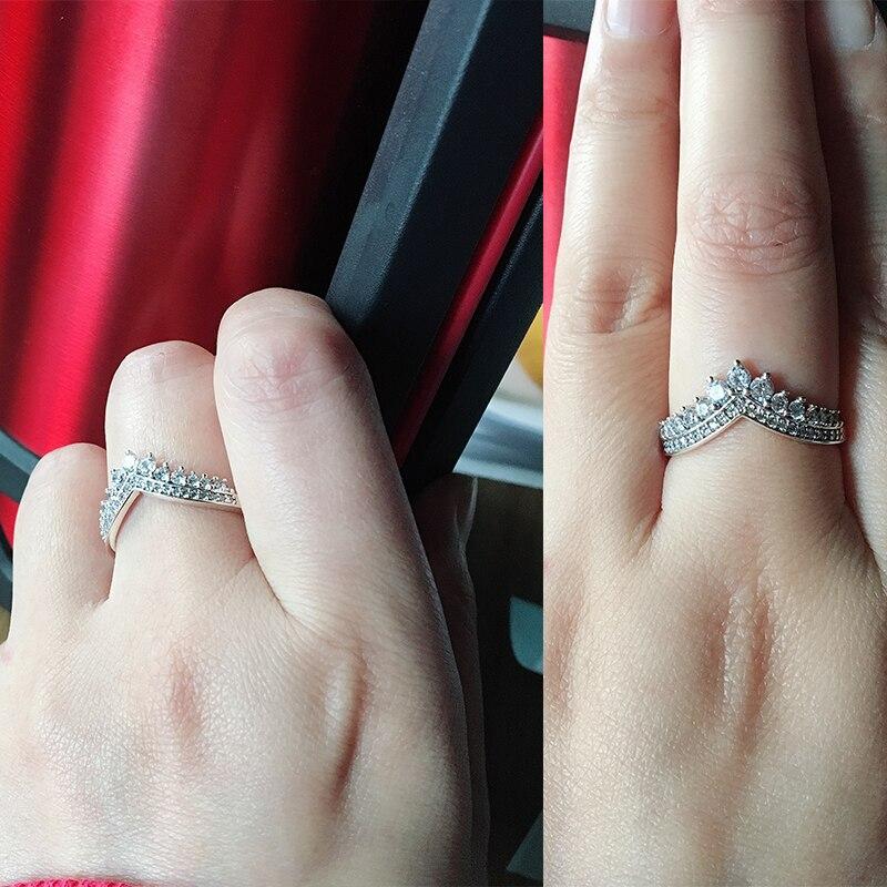 Elegant V-ring i silverfärg med glänsande kristaller, perfekt som damring för både vardag och fest.