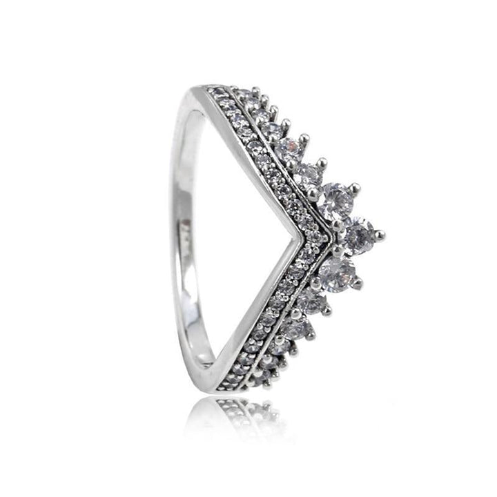 Sofistikerad V-formad silverring med gnistrande kristaller, en damring som utstrålar elegans.