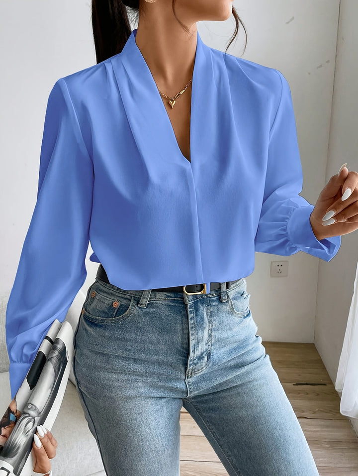 Elegant v-ringad damblus i ljus polyester, perfekt som sommarblus eller till kontoret