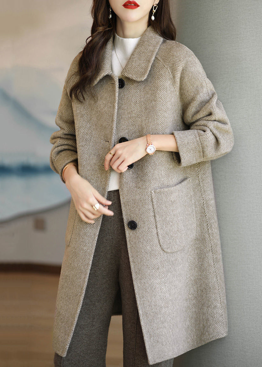 Elegant kvinnors kappa i brun patchwork-design med stilfulla fickor, ett varmt och modernt ytterplagg.