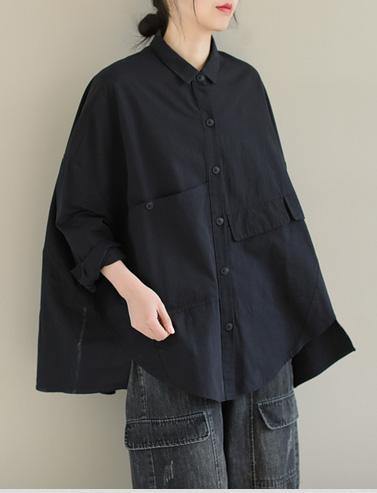 Detailbild av kragen på en vit asymmetrisk kortärmad blus, ren & stilren design