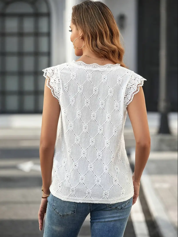 Kvinnors chic festtopp i vitt med stilren V-ringning. Detaljerat broderi ger en sofistikerad look.