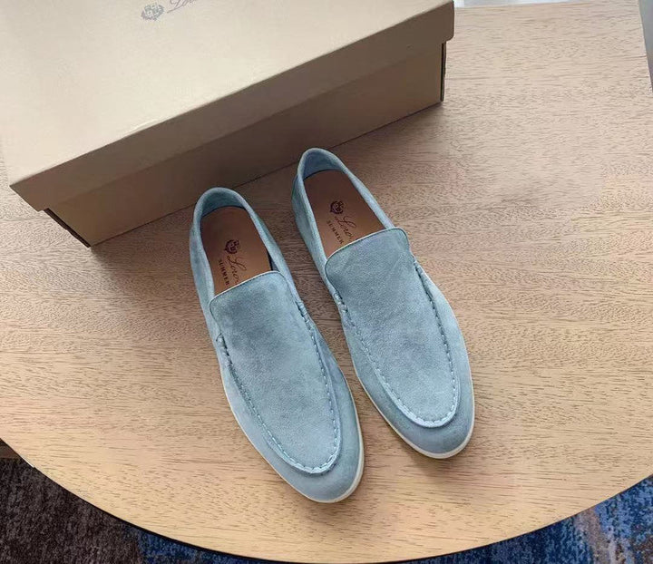 Män som bär klassiska herr loafers i elegant vintage stil. Bekväma slip-on skor för en sofistikerad look.