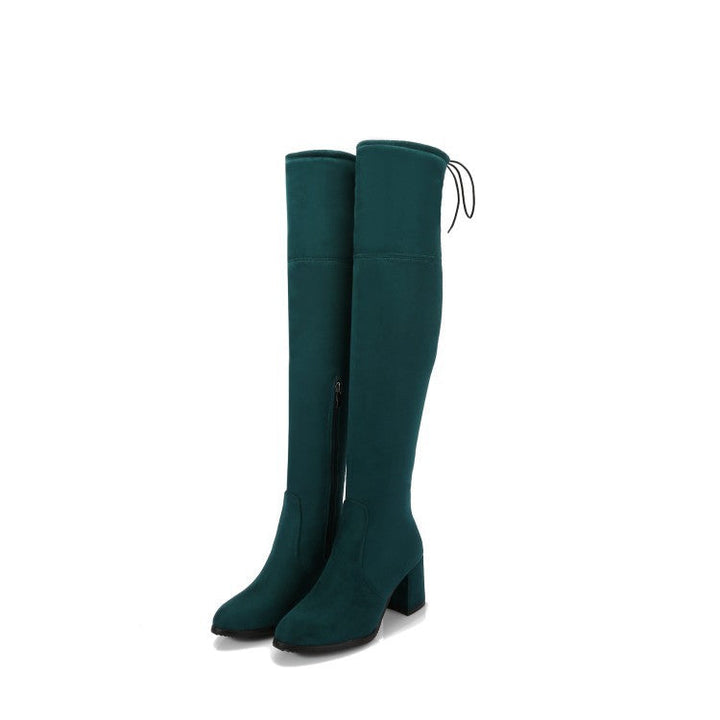 Kvinnors överknästövlar, en modefavorit för höst och vinter, finns i mörkgrön för en chic look.