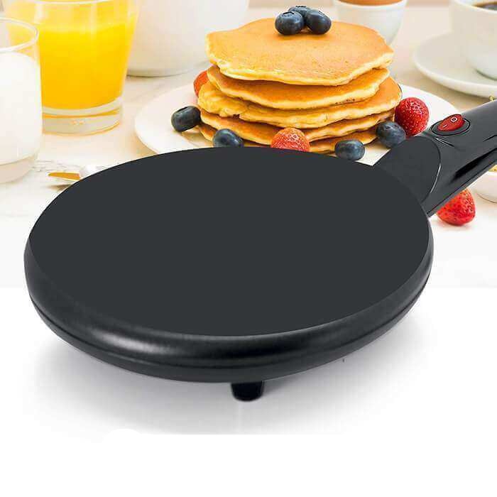 Kompakt elektrisk crêpemaskin med träspatel och spridare, enkel att använda för frukost.