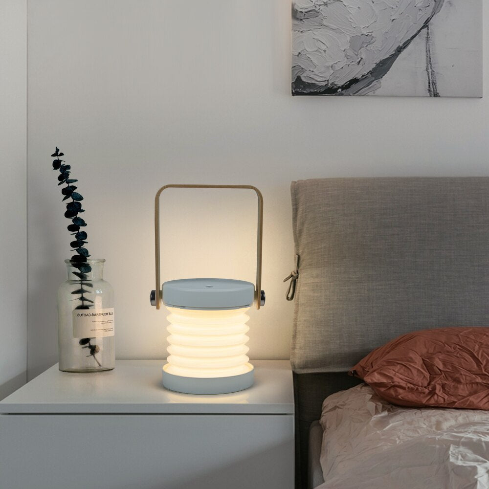Uppladdningsbar LED-tältlampa i grått/vitt, touchkontroll och fällbar för maximal flexibilitet utomhus.