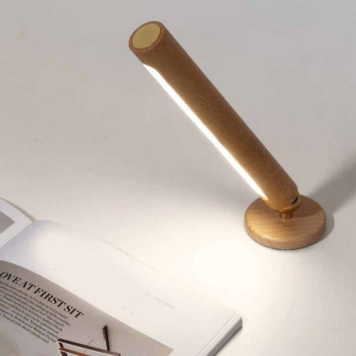 Magnetisk LED-lampa i ljust trä, flexibel att fästa på olika ytor som vägg eller hylla.