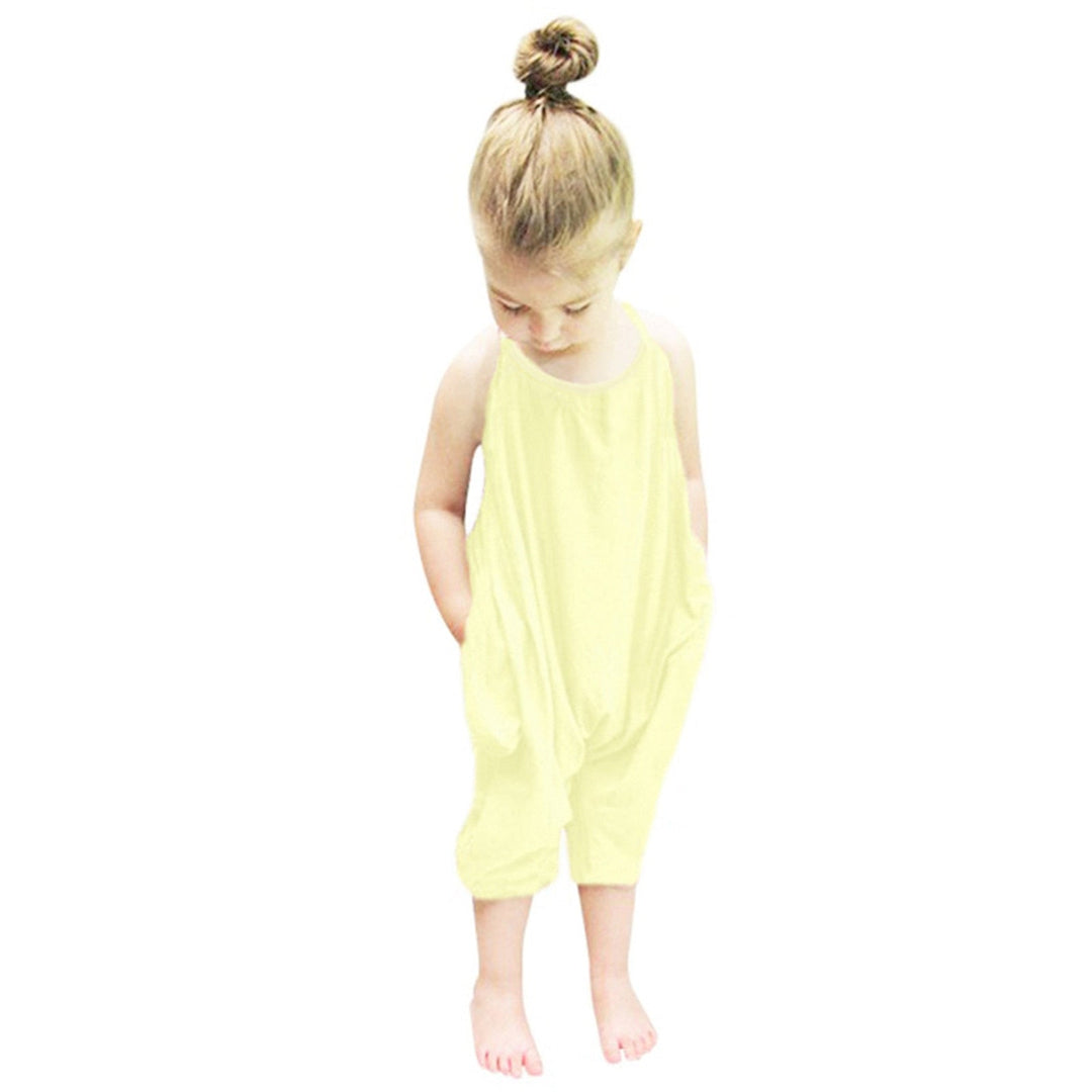 Närbild på en barnjumpsuit med halterneck och rosett, betonar bekvämt tyg och design.