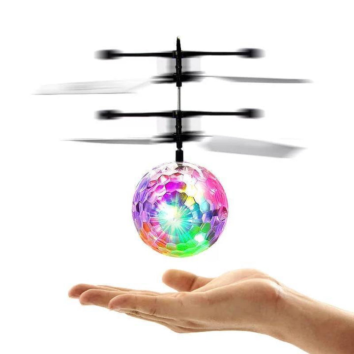 Barn ler när de leker med en glödande flygande induktionsboll inomhus.