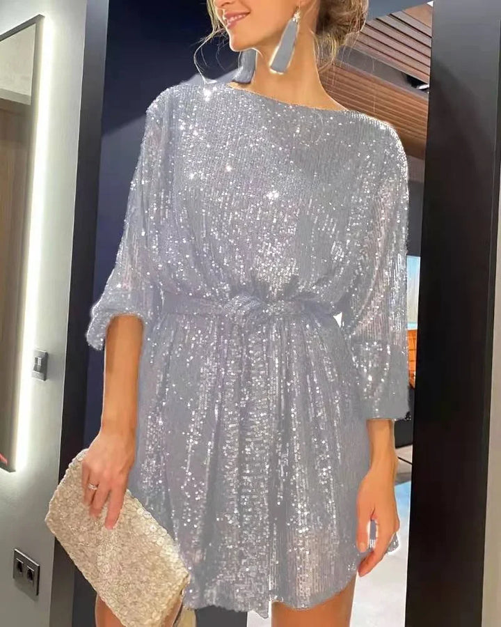 Kvinna i glittrig paljettklänning, en glamourös damklänning med glitter för fest och speciella tillfällen.