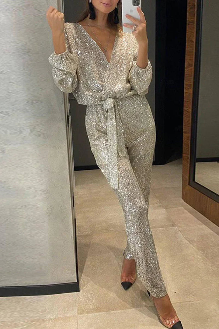 Gnistskande kvinnors paljettjumpsuit med V-ringning. Glamourös festbyxdress för en oförglömlig kväll.
