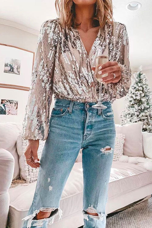 Elegant långärmad paljettblus i svart med V-hals som passar både till fest och uppklädd vardagsstil.