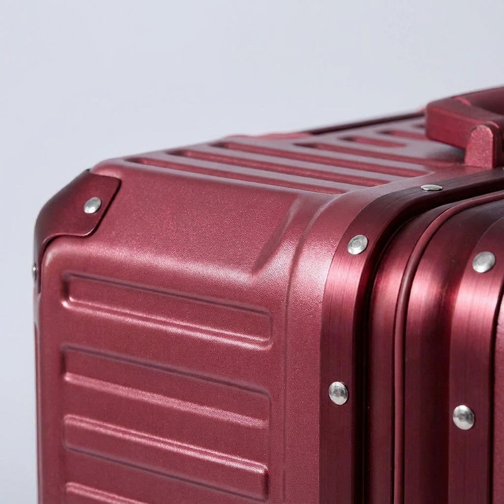 Röd aluminiumförstärkt resväska med robust konstruktion och TSA-lås för hållbart och säkert bagage.