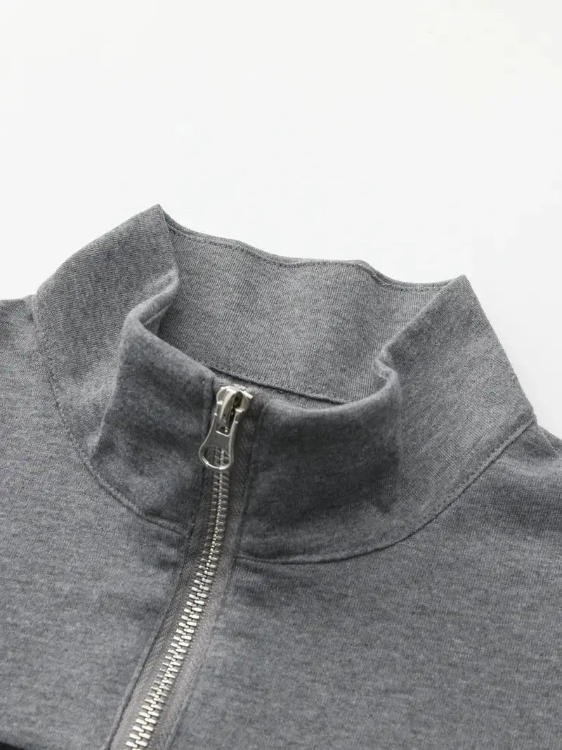Man bär en värmande, svart herrtröja med halvdragkedja i fleece. Perfekt för vintermode och ledig stil.