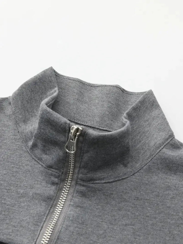 Man bär en värmande, svart herrtröja med halvdragkedja i fleece. Perfekt för vintermode och ledig stil.