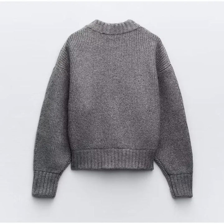 Kvinna bär grå långärmad dragkedjetröja. Bekväm damtröja för höstmode och avkopplande stunder.