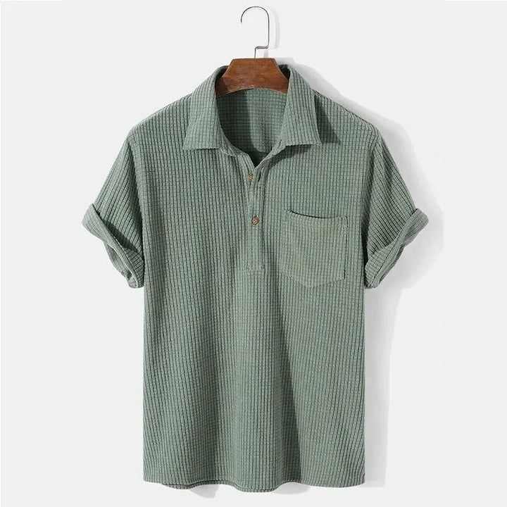 Blå våffelmönstrad pikétröja för herrar. Bekväm casual stil, idealisk för vårmode och vardagslook.