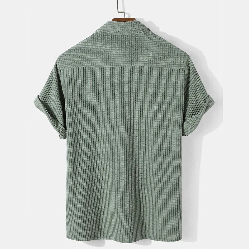 Khaki herr polo skjorta med våffelmönster och avslappnad passform. Modern piké för sommarkläder.