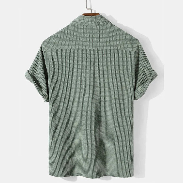 Khaki herr polo skjorta med våffelmönster och avslappnad passform. Modern piké för sommarkläder.