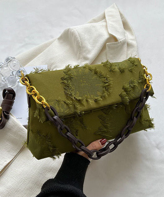 Trendig grön messenger axelväska med unika patchworkdetaljer, kedjerem och tofsar. En chic accessoar för vardagen.