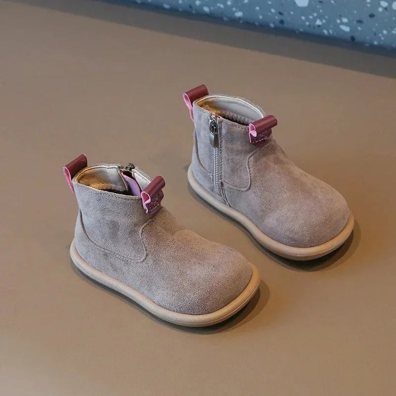 Närbild av den halkfria sulan på barnens ankelkängor i mocka, med bambusko-detalj.