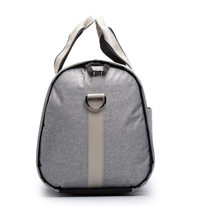 Man bär en grå vattentålig dufflebag. Perfekt som handbagage för affärsresa och pendling. Organiserad stil.