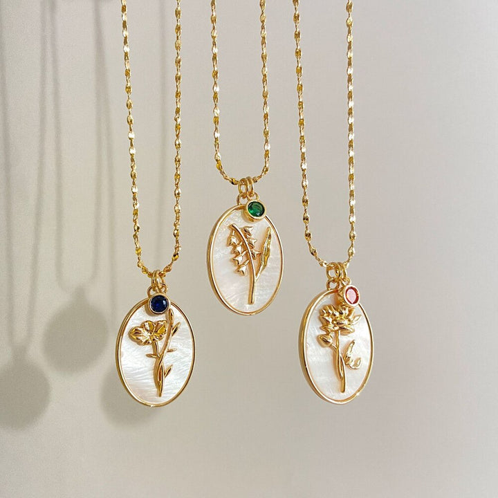 Modernt kvinnors halsband som kombinerar guldplätering med zirkoner och födelsemånadsblomma.
