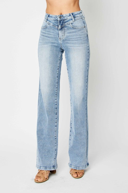 Detaljerad bild på retro damjeans med hög midja i mellanblå denim, visar textur och söm.