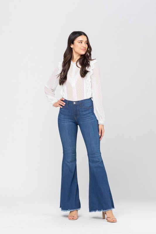 Detaljbild av de högmidjade flared jeansen som framhäver den avslappnade passformen och denimkvaliteten.