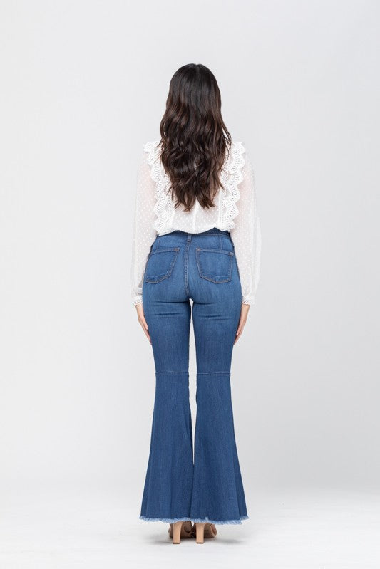 Kvinnomode: En modell bär de trendiga blå högmidjade flared jeansen med en stilren topp.