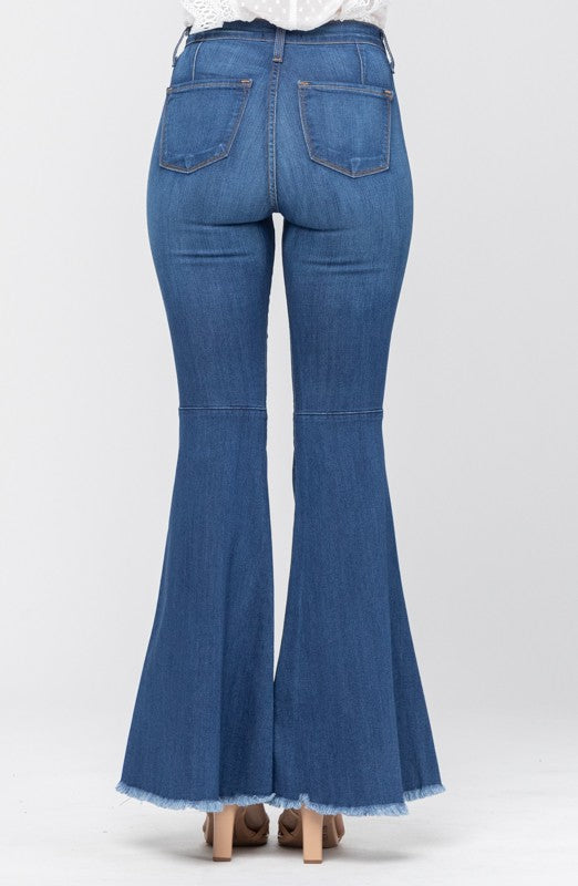 Modell poserar i blå högmidjade flared jeans, en tidlös stil för avslappnat kvinnomode.