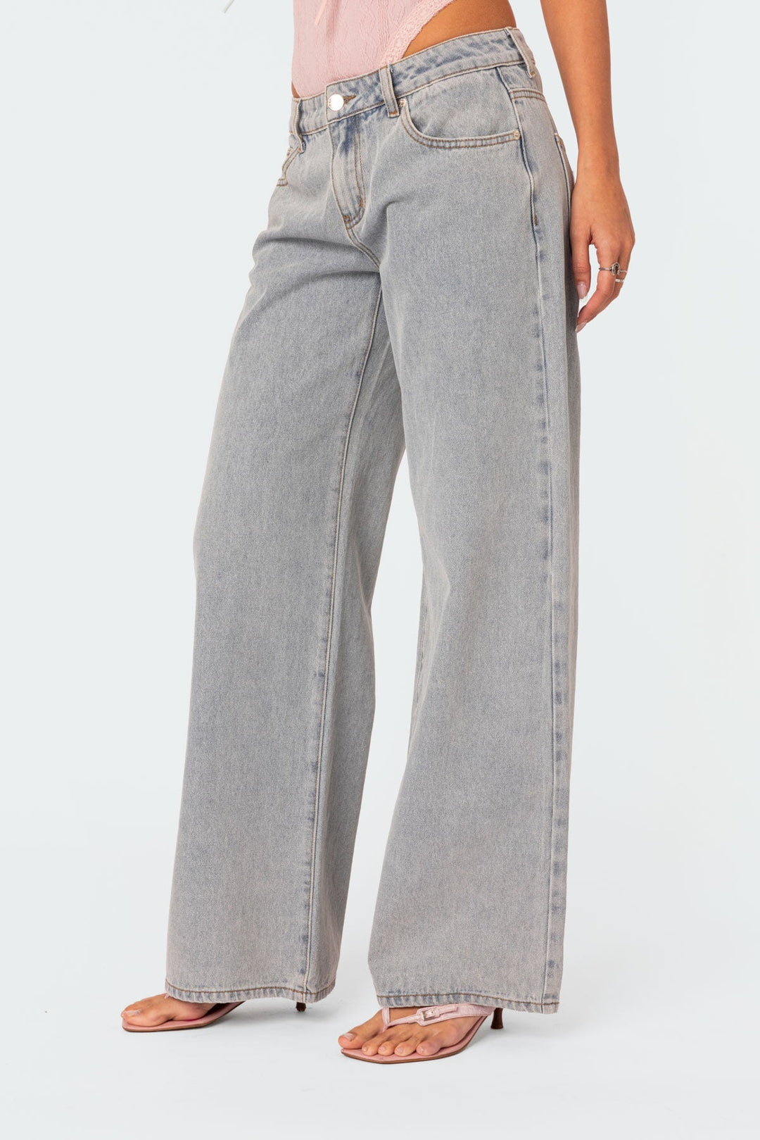 En kvinna poserar i moderna flarejeans i denim, som framhäver den trendiga skärningen och mångsidigheten i damkläder.