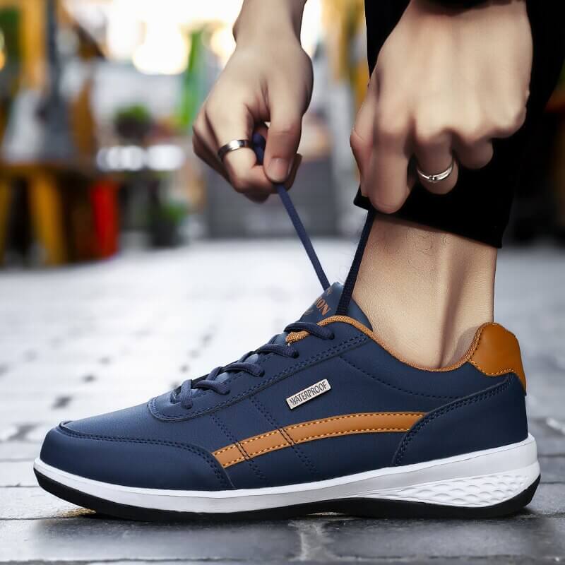 Herr sneakers, prestandafokuserade, svarta med röda accenter, dämpande sula, från sidan