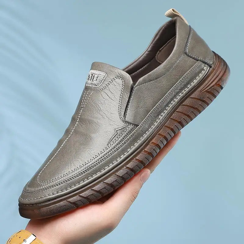 Herr loafers i PU-läder, svart och brun, sida vid sida, visar färgalternativen för denna bekväma sko.