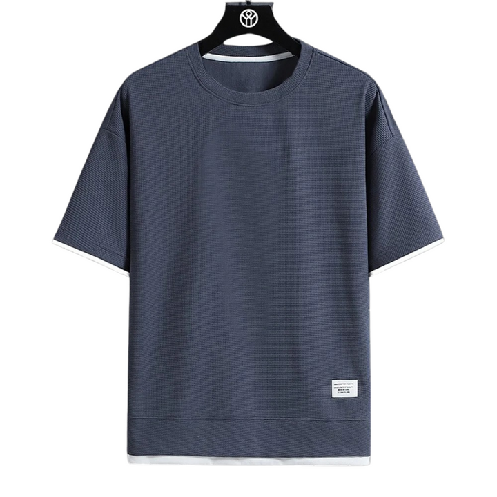 Man i kortärmad våffel T-shirt, bekvämt och stilrent val för en avslappnad vardagslook.
