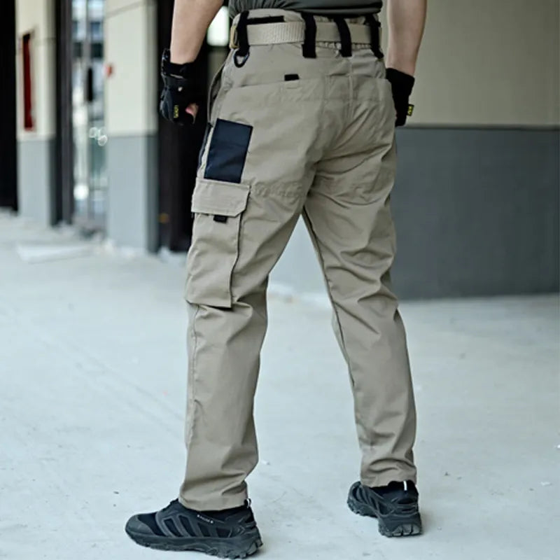Hängande taktiska herrbyxor med vattentålig ripstop, redo för utmanande vandring.