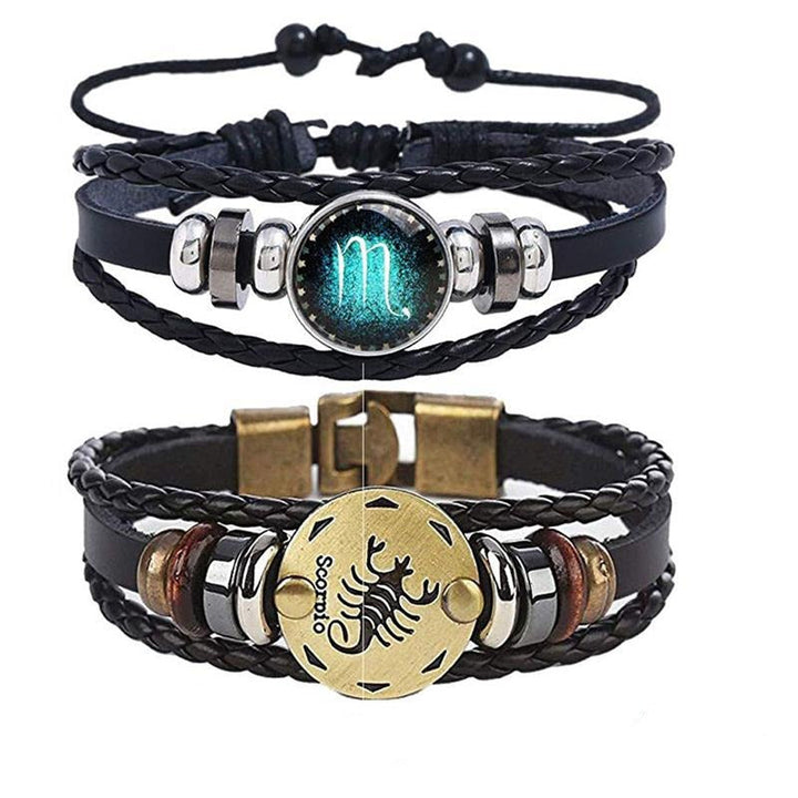 Detaljbild av herrarmband med zodiak charm i metall mot konstläderrem. Personligt smycke.