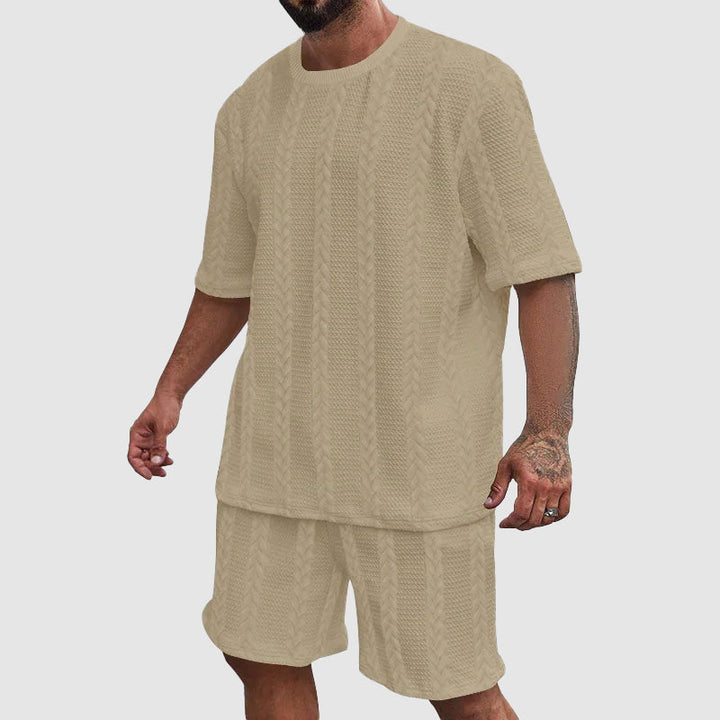 Man bär urban träningskostym för herrar, ett bekvämt shortsset för sport, fritid och sommaraktiviteter.