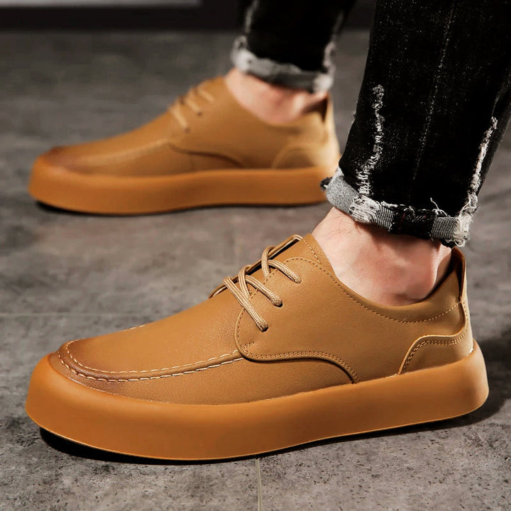 Herrars gråa casual skor i mockasinstil på fötter. Bekväma och stilrena platta vardagsskor för sommar.